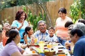 A family having fun sitting around a table for thanksgiving enjoying food with a cool bounce house rental